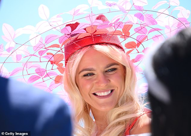 She made sure to turn heads as she teamed her stylish ensemble with a unique headpiece, made up of a bright red hat and rings adorned with colourful leaves