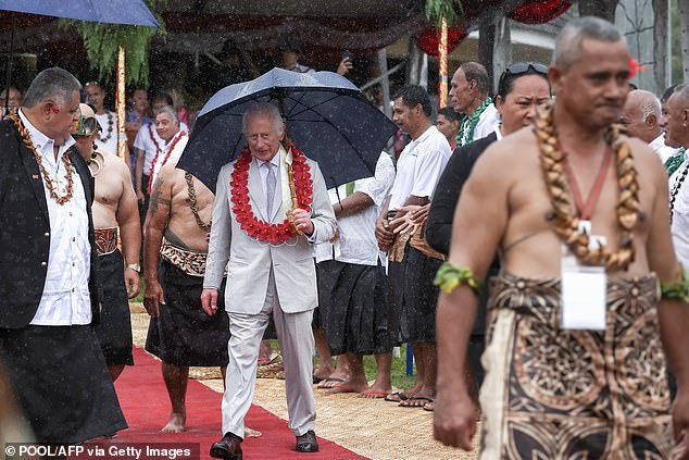 The King and Queen later sheltered under umbrellas when they boarded their plane home in torrential rain