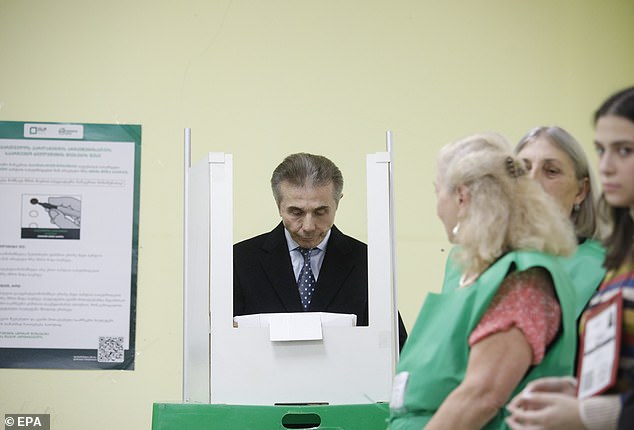 Bidzina Ivanishvili (C) casts his ballot at a polling station in Tbilisi, Georgia, 26 October 2024