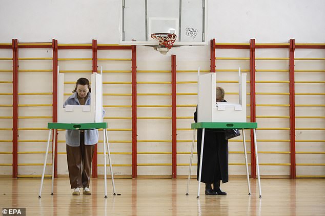 Georgian people cast their ballots during parliamentary elections, at a polling station in Tbilisi, Georgia, 26 October 2024