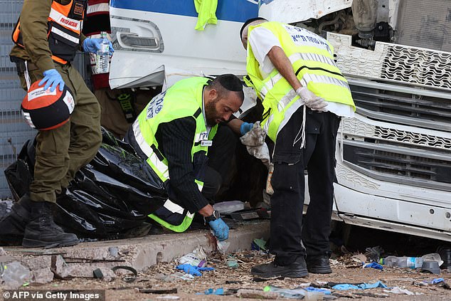 Israeli emergency responders clean the site after a driver rammed his truck into a crowd of people at a bus stop in Ramat Hasharon, north of Tel Aviv on October 27, 2024