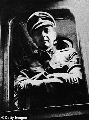 Mengele standing at a train window in his SS uniform