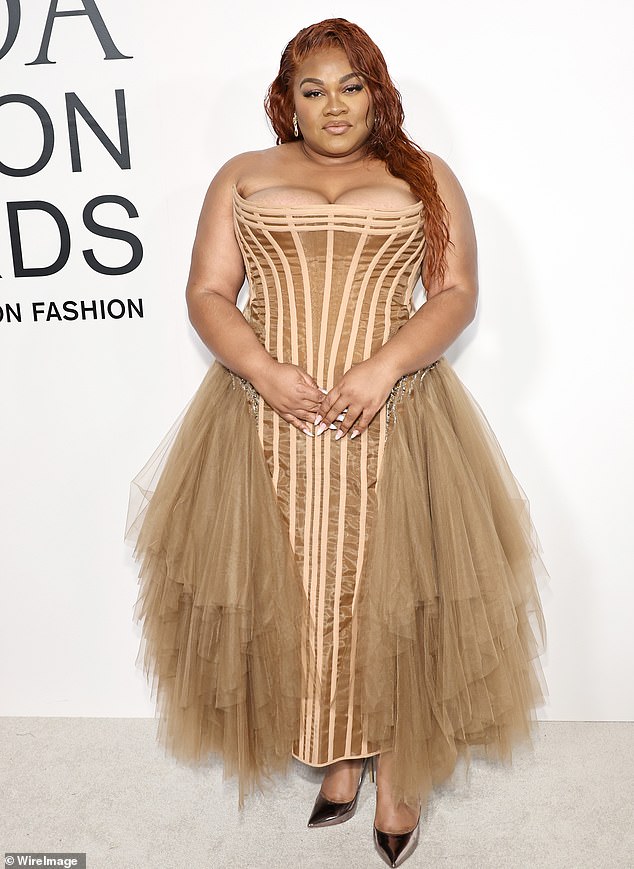 Da'Vine Joy was classy in a strapless, dark gold corset-styled dress that had tulle details on each side