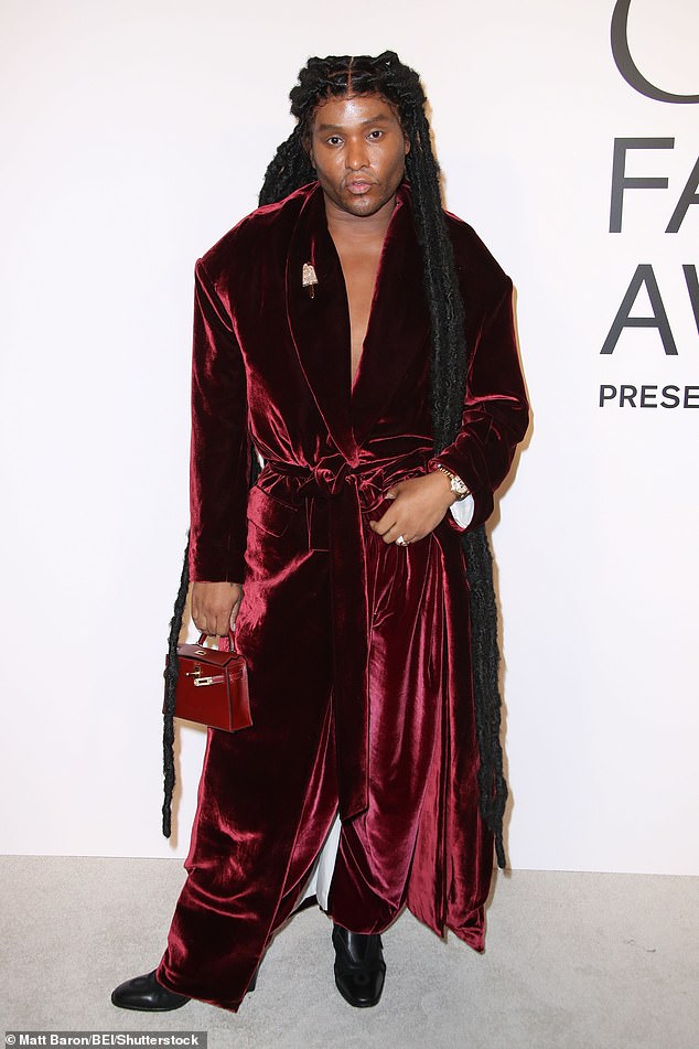 Law Roach dressed to impress wearing a dark, red velvet ensemble as well as a pair of black boots. The stylist carried a red bag and added a flashy, gold watch on his left wrist