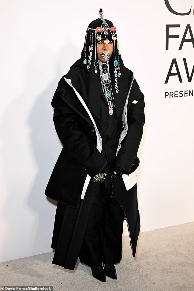 Erykah Badu donned an all-black ensemble that was layered with a black coat with a white trim