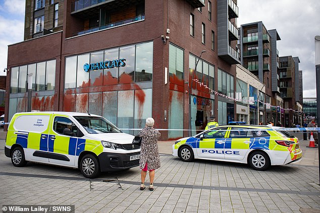 Police officers surround a Barclays bank branch in Bury, Manchester after windows were smashed and red paint was sprayed. Palestine Action have claimed responsibility for the damage in protest to the investment Barclays have in arms to Israel