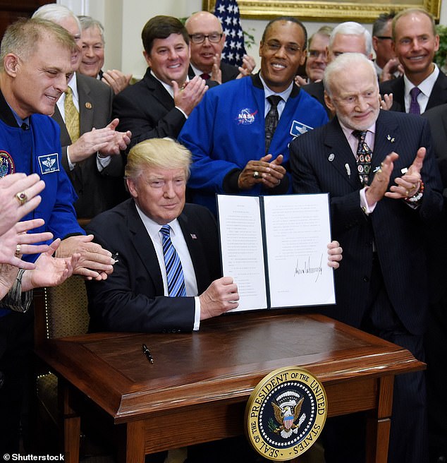 Aldrin was present in the Oval Office, standing at the former president's side , when the National Space Council was reinstated after being disbanded in 1993