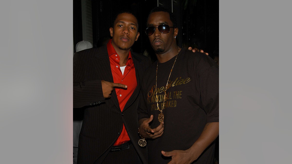 Nick Cannon wears red shirt and suit with Sean Diddy Combs.