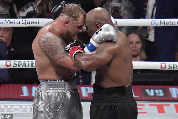 Jake Paul and Mike Tyson embrace after their heavyweight boxing match, Friday, Nov. 15, 2024, in Arlington, Texas. (AP Photo/Julio Cortez)