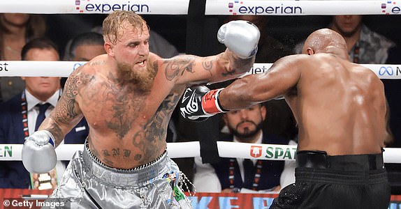 ARLINGTON, TEXAS - NOVEMBER 15: Jake Paul (L) punches Mike Tyson during their heavyweight bout at AT&T Stadium on November 15, 2024 in Arlington, Texas. (Photo by Christian Petersen/Getty Images)