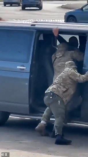 He grabs onto the frame of the car in a last ditch attempt to save himself