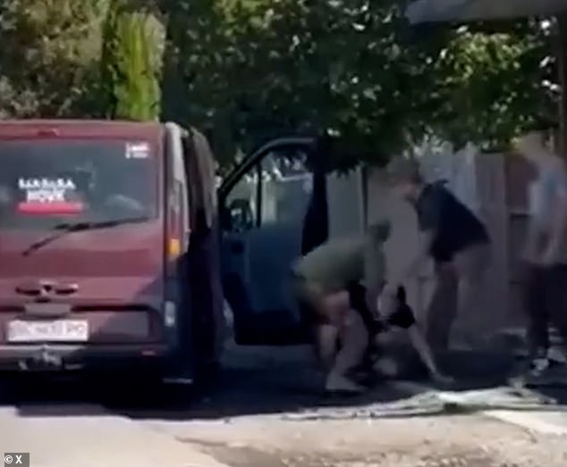 Another video shows officers holding a man and seemingly trying to put him into the van