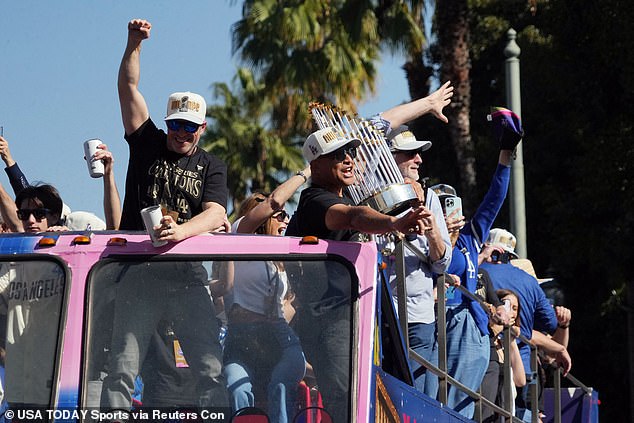 Los Angeles Dodgers managers Dave Roberts holds the World Series trophy during the parade