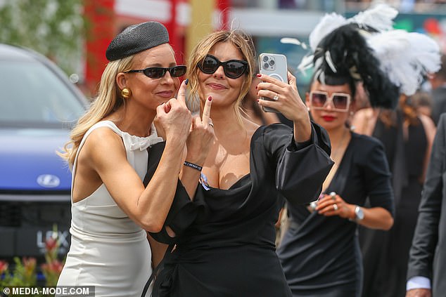 Lauren went for a more revealing low-cut black dress on Derby Day. She is seen cheekily flipping the bird in the Birdcage with Carrie Bickmore