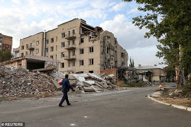 A man walks past a building damaged by a Russian military strike in the town of Pokrovsk, amid Russia's attack on Ukraine, in Donetsk region