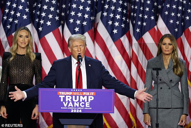 Donald Trump smiles on stage as he is flanked by his wife Melania (right) and his daughter-in-law Lara (left)