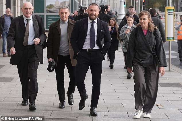 Conor McGregor (second right) with his father Tony McGregor (second left) outside the High Court in Dublin on November 6