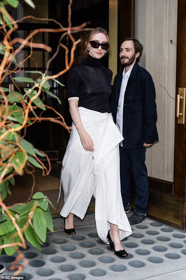 Her first look featured a slim, semi-sheer black mock turtleneck that she wore over a white short-sleeve blouse. She brightened up the dark top with her flowing white culottes