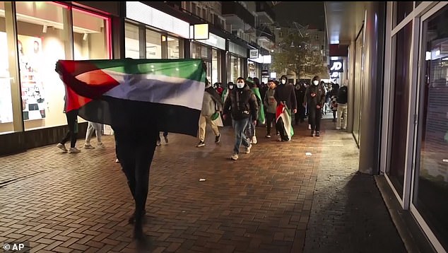 Pro-Palestinian supporters march with Palestinian flags near the Ajax stadium in Amsterdam