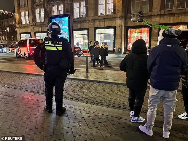 Israeli Maccabi Tel Aviv supporters are guarded by police after violence targeting Israeli football fans broke out in Amsterdam overnight