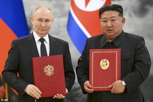 Russian President Vladimir Putin, left, and North Korea's leader Kim Jong Un pose for a photo during a signing ceremony of the new partnership in Pyongyang