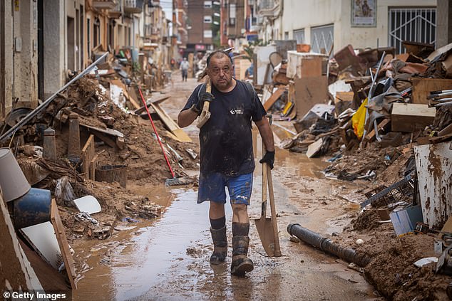 A man cleans his house after heavy rain and flooding hit large parts of the country on November 04, 2024 in Paiporta, Spain