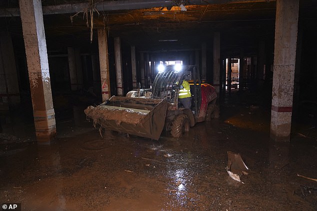 Mud is scooped up after floods in Catarroja that left hundreds dead or missing in the Valencia region in Spain, Tuesday, Nov. 12, 2024