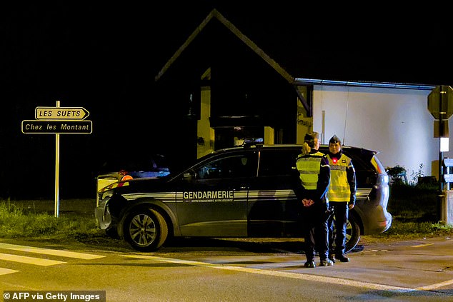 French gendarmes stand guard at the entrance of street near the location where three children were found dead in Taninges, on November 12, 2024