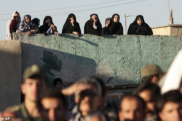 Under Iran's sharia law, a victim's family can ask for blood money to spare the life of the perpetrator or also decide to forgive. Pictured: Local people watch as a hanging is carried out