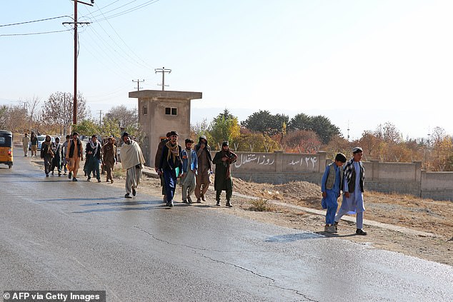 Afghans walk towards a football stadium ahead of the public execution of a man, by the Taliban at Gardez in Paktia province on November 13, 2024