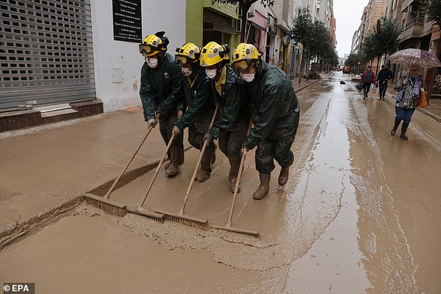 Firefighters from Malaga city work to clean up the flood-hit city of Catarroja, province of Valencia, eastern Spain, 13 November 2024