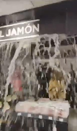 Water is seen gushing down from the ceiling in a shopping centre