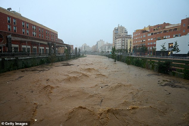 Choppy high waters are seen flowing down the river running through Malaga city centre