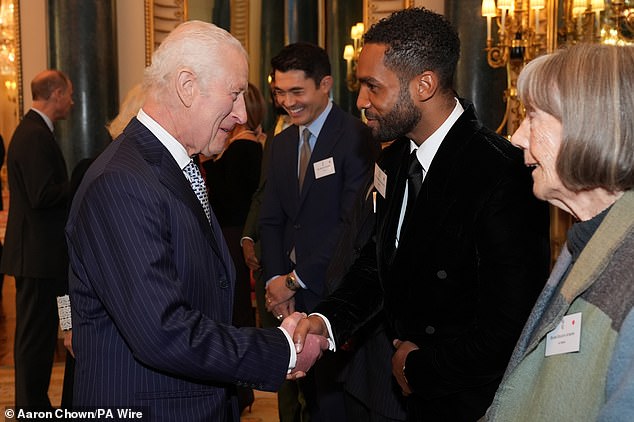 Pictured: A smiling Charles meeting with Lucien Laviscount, among a host of other talented actors