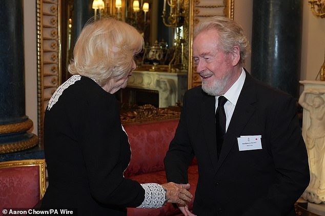 Charles, 75, donned a dapper navy pinstripe suit for the occasion, whereas Camilla, 77, sported an elegant black dress with white detailing around the collar and sleeves. The Queen pictured with Ridley Scott