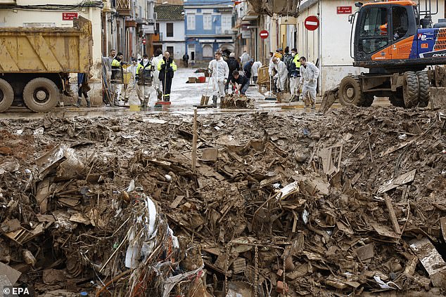 Volunteers clean the street in Paiporta, province of Valencia, eastern Spain, 13 November 2024