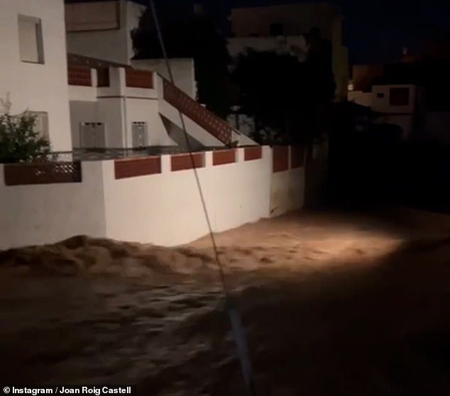 Floodwaters rip past homes in southeastern Spain