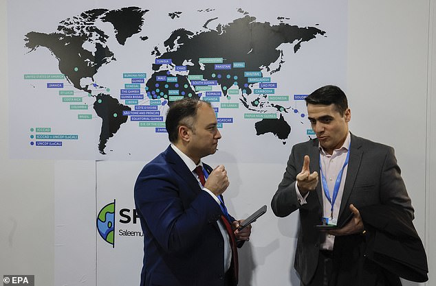 Participants talk as they visit an exhibition at the United Nations Climate Change Conference COP29 in Baku