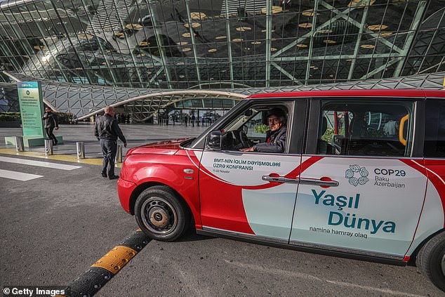 An electric taxi is parked in front of a terminal of the Heydar Aliyev International Airport ahead of the COP29 United Nations Climate Change Conference on November 3