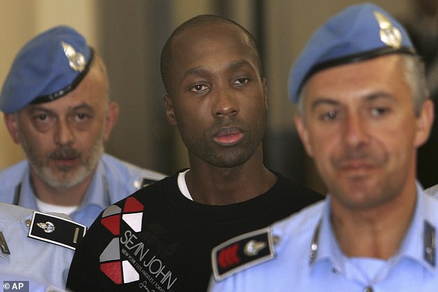 Rudy Hermann Guede, center, is escorted by Italian penitentiary police officers as he leaves Perugia's court, Italy, Friday, Sept. 26, 2008. Guede was convicted for the slaying of Meredith Kercher in Perugia, Italy