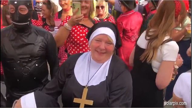 Pictured: Revellers dressed as a nun and a gimp are pictured out on the streets of Benidorm