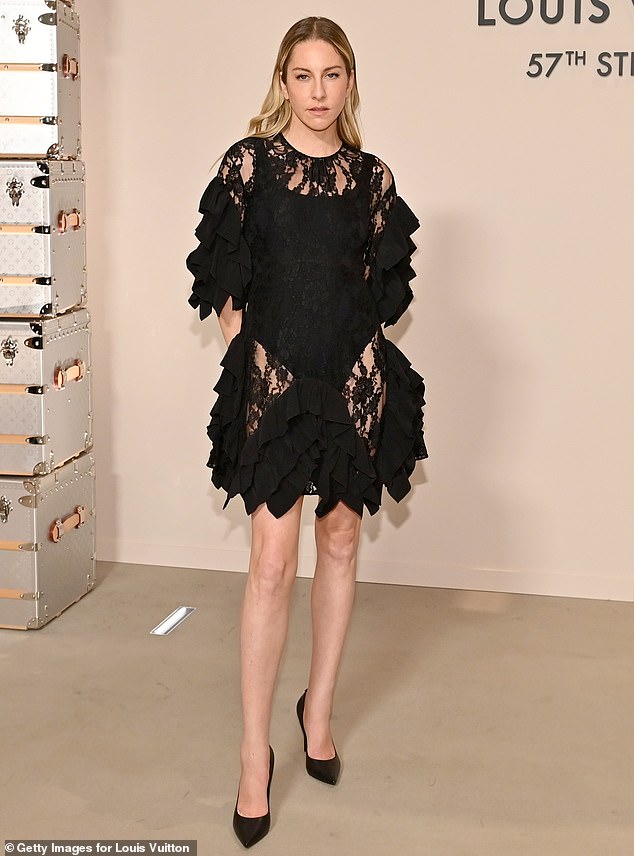 Este Haim put on a leggy display wearing a sheer, black minidress made of lace material and ruffled detail