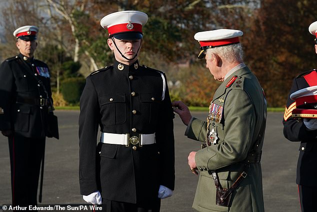 King Charles III, as Captain General Royal Marines, awards Marine Osian Stephens the King's Badge