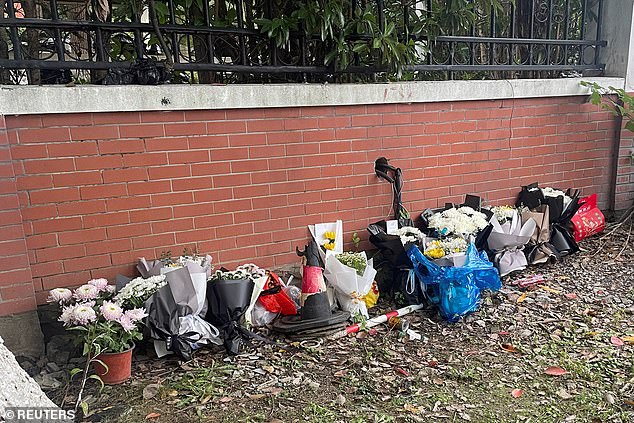 Floral tributes are placed near an entrance to the Wuxi Vocational College of Arts and Technology following a knife attack, in Wuxi, Jiangsu province, China November 17, 2024