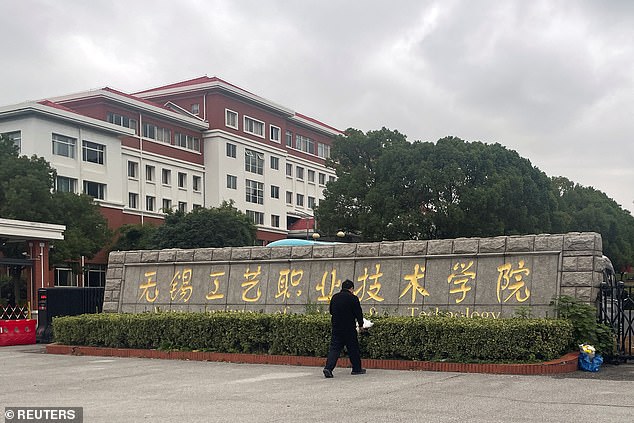 A man lays a bouquet of flowers at an entrance to the Wuxi Vocational College of Arts and Technology following a knife attack, in Wuxi, Jiangsu province, China November 17, 2024.