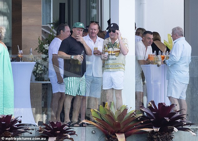 Karl dressed casually in striped shorts and a black T-shirt as he enjoyed a beer