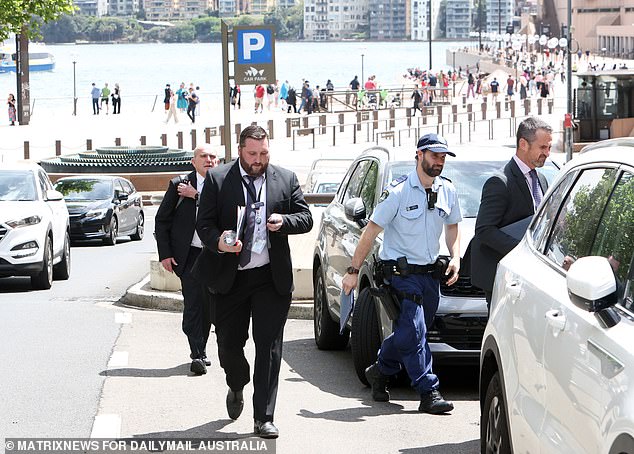 Police are pictured leaving Alan Jones' apartment in Sydney on Monday