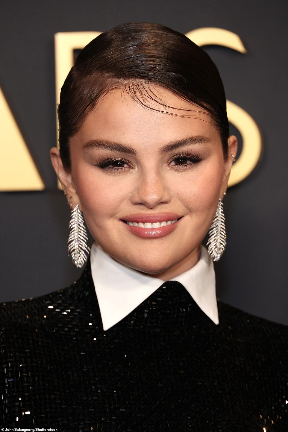 Unique shimmering feather earrings spruced up her look