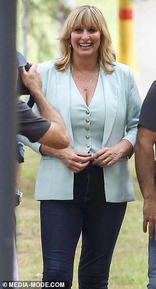 The TV personality showed off her trim physique and flashed her cleavage in a tight pale blue vest and blazer