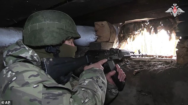 A Russian soldier aims from a bunker in the Russian - Ukrainian border area in Kursk